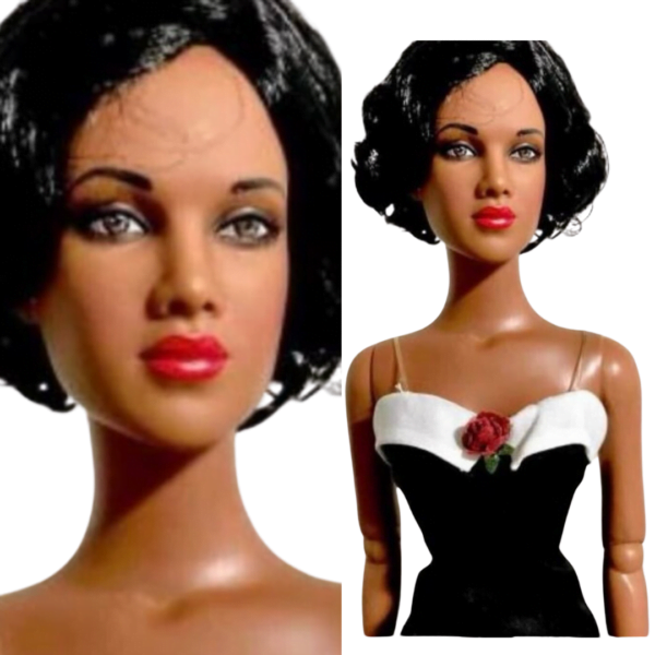 A glamorous fashion doll dressed in a black swimsuit with a white collar and red flower accent, standing on a display stand. The doll features intricate hand-painted details and embodies the elegance of classic Hollywood glamour.